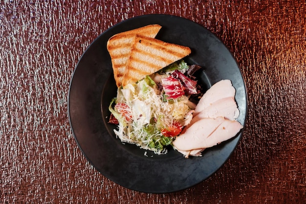 Caesar salad with chicken on the table top view