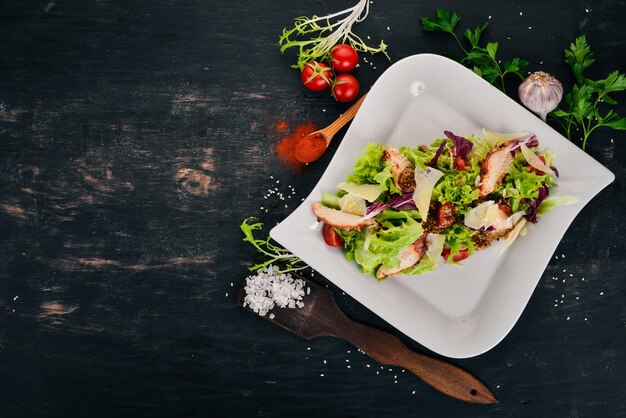 Caesar salad with chicken Top view On a wooden background Copy space