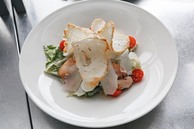 Photo caesar salad with roasted chicken breast croutons cherry tomatoes and parmesan on white plate