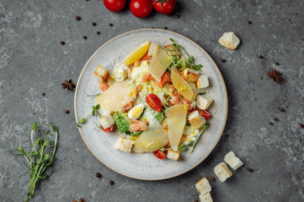 Caesar salad with salmon and fresh vegetables. Top view. Free space for your text