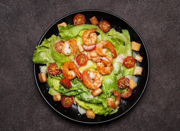 Caesar salad with shrimp, croutons and parmesan, top view