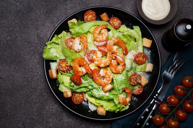 Caesar salad with shrimp, croutons and parmesan, top view