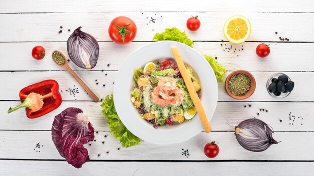 Caesar salad with shrimp On a white wooden background Top view Copy space for your text