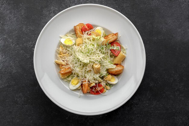 Caesar salad with shrimps on a dark background