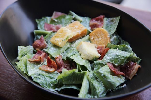 Caesar salad on wood background