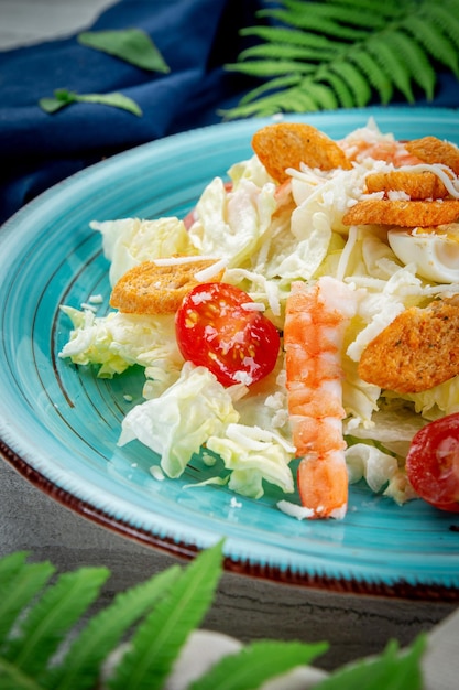 Caesarsalade met garnalen in een bord op een lichttafel