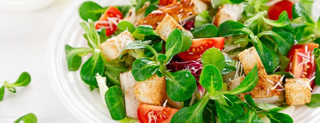 Caesarsalade met gegrild kippenvlees verse tomatencroutons veldsla en parmezaanse kaas Gezonde lunch Bovenaanzicht Banner