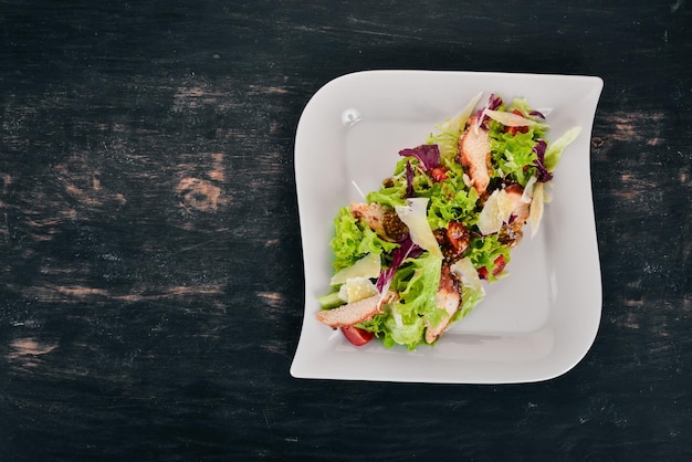 Caesarsalade met kip Bovenaanzicht Op een houten achtergrond Kopieer de ruimte