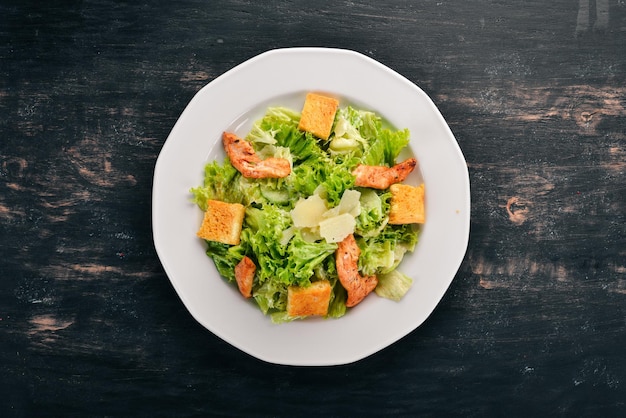 Caesarsalade met kip en verse groenten Op een houten ondergrond Bovenaanzicht Kopieer de ruimte