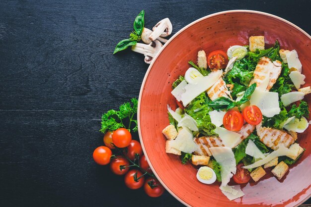 Caesarsalade met kip en verse groenten Op een houten ondergrond Bovenaanzicht Vrije ruimte voor uw tekst