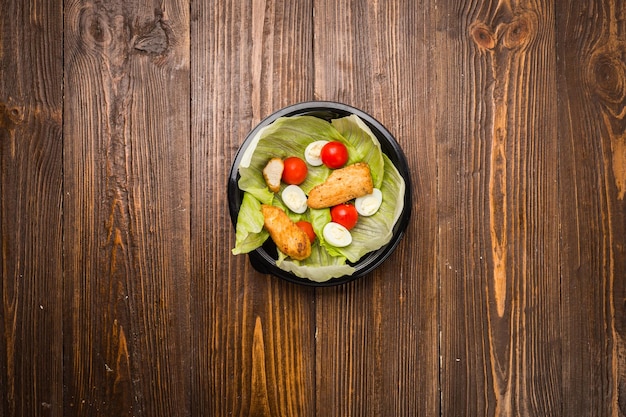 Caesarsalade met kippenkerstomaten en kwarteleitjes op een bord