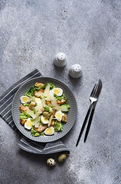 Caesarsalade met kippensaus en parmezaanse kaas op concrete achtergrond