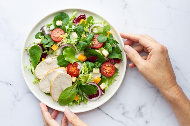 Foto caesarsalade met kippensla, tomatenkaas en saus op witte achtergrond