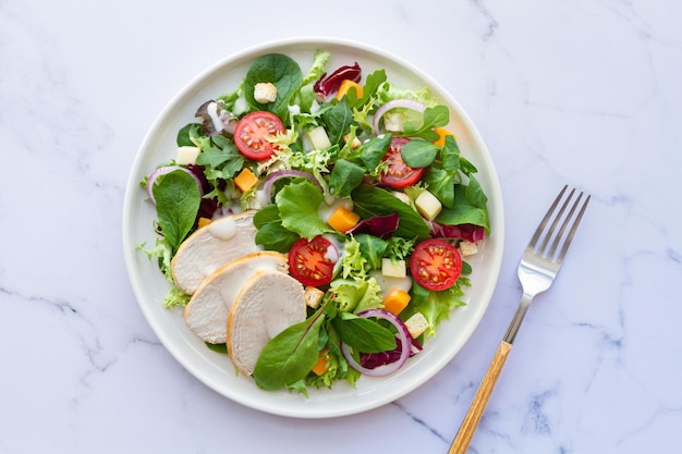 Foto caesarsalade met kippensla, tomatenkaas en saus op witte achtergrond