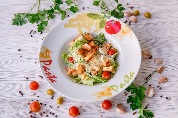 Caesarsalade met zeevruchten, op het bord staat pasta.