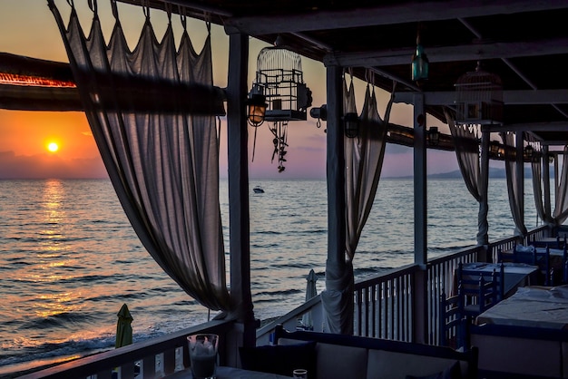 Café bij de zee van ruwe planken met gordijnen in de schemering of bij zonsopgang
