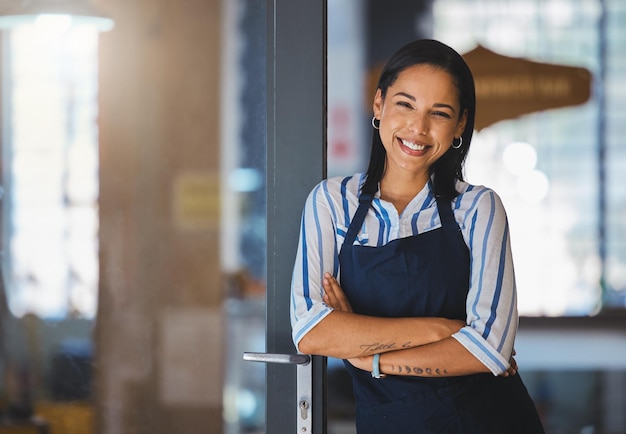 Cafe or coffee shop barista entrepreneur and female small business owner of successful modern startup or restaurant Happy positive and empowered woman leader with welcoming door open for business