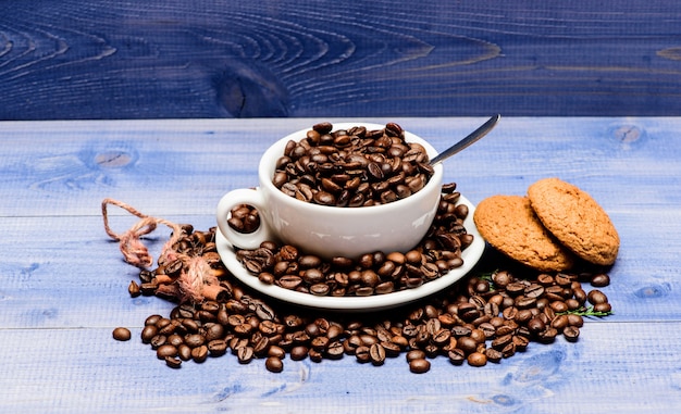 Café drankenkaart. Arabica robusta koffiesoort. Drank voor inspiratie en energielading. Kop vol koffie bruin geroosterde boon blauwe houten achtergrond. Vers gebrande koffiebonen. Cafeïne-concept.