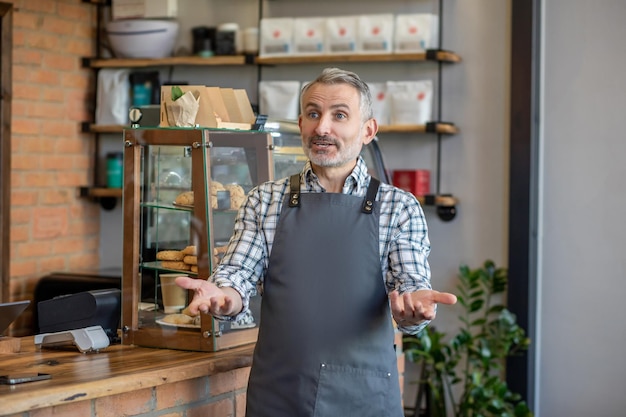Café-eigenaar verwelkomt klanten in zijn etablissement