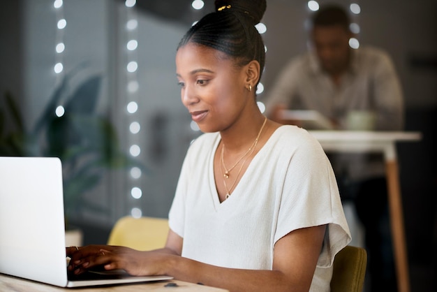 The cafe inspires her to stay productive Shot of a young woman using a laptop in a cafe