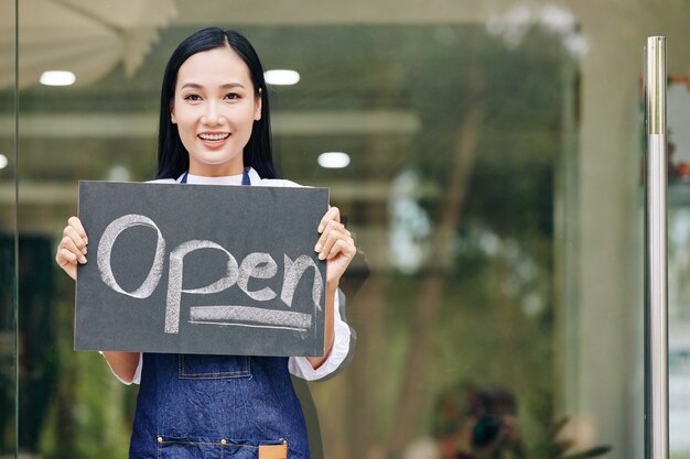 Cafe owner showing open sign