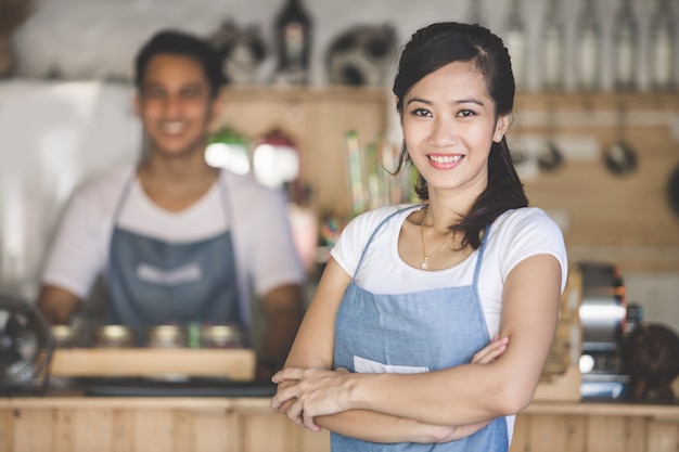 Proprietario del caffè in piedi con le braccia incrociate