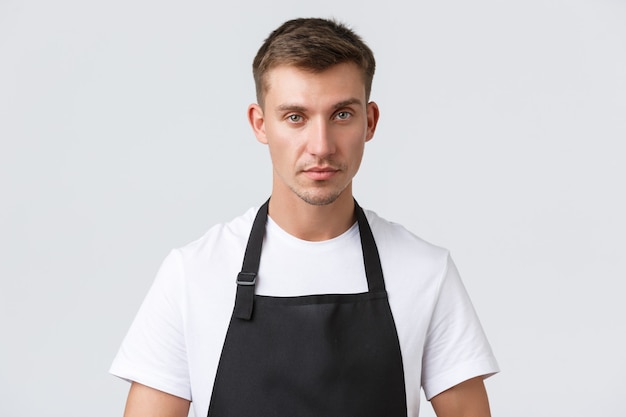 Cafe and restaurants, coffee shop owners and retail concept. Close-up of handsome waiter serving tables, taking client order, looking determined, listening to guest, standing white background