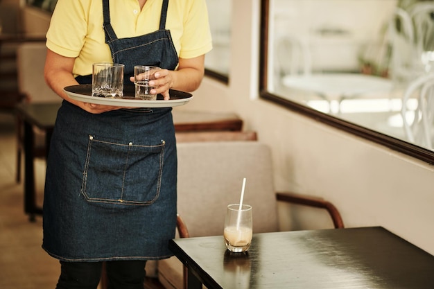 Cafe serveerster verzamelt vuile glazen