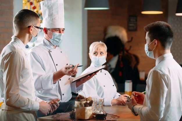 Cafe staff on morning briefing wearing protective masks.