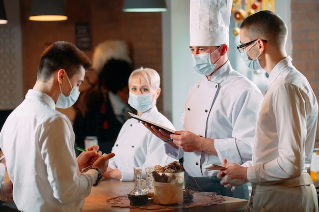 保護マスクを着用した朝のブリーフィングのカフェスタッフ