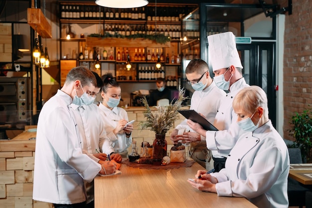 Foto il personale del bar durante il briefing mattutino indossa maschere protettive.