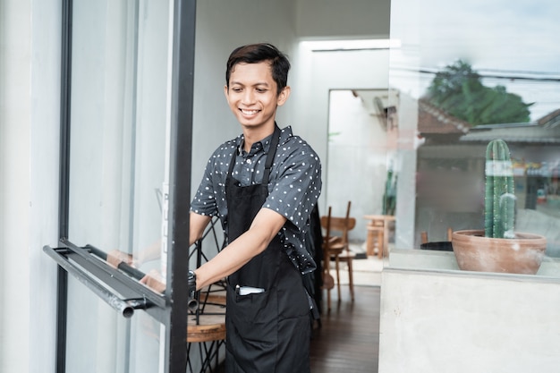 Cafe waitress smile when open the door glass