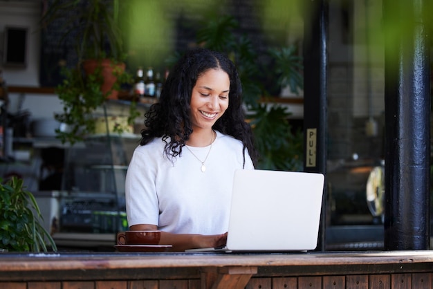 カフェで働く女性とオンライン プロジェクトの電子メールまたは販売提案のためにラップトップで入力する女性