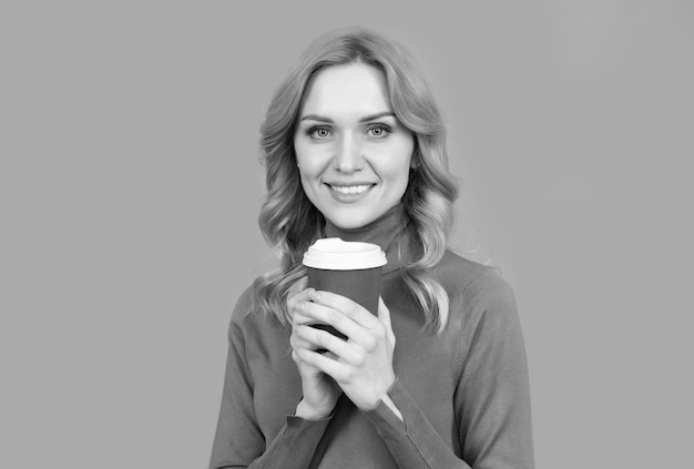 Кофеин возбуждает меня Счастливая женщина держит чашку на сером фоне Наслаждаясь напитком с кофеином