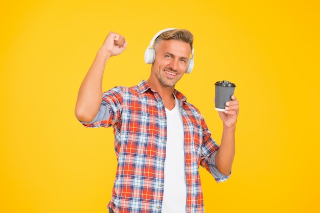 Caffeine gives him energy Happy man make power gesture holding coffee cup Caffeine addicted Natural stimulant Takeaway drink Modern lifestyle Dark and refined freshness