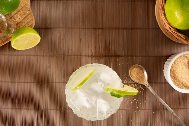 Caipirinha glas Pinga Cocktail met citroen op een houten plaat achtergrond in een luchtfoto van boven