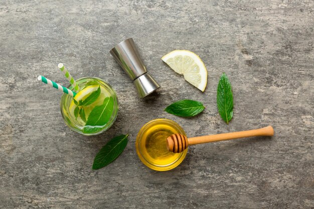 Caipirinha Mojito cocktail vodka or soda drink with lime mint and straw on table background Refreshing beverage with mint and lime in glass top view flat lay