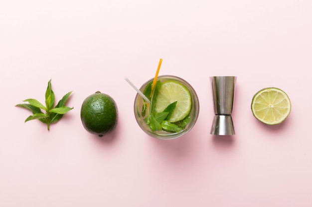 Caipirinha Mojito cocktail vodka or soda drink with lime mint and straw on table background Refreshing beverage with mint and lime in glass top view flat lay