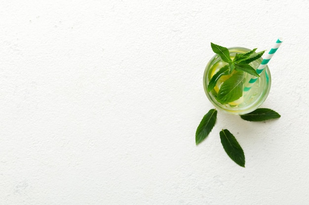 Caipirinha Mojito cocktail vodka or soda drink with lime mint and straw on table background Refreshing beverage with mint and lime in glass top view flat lay