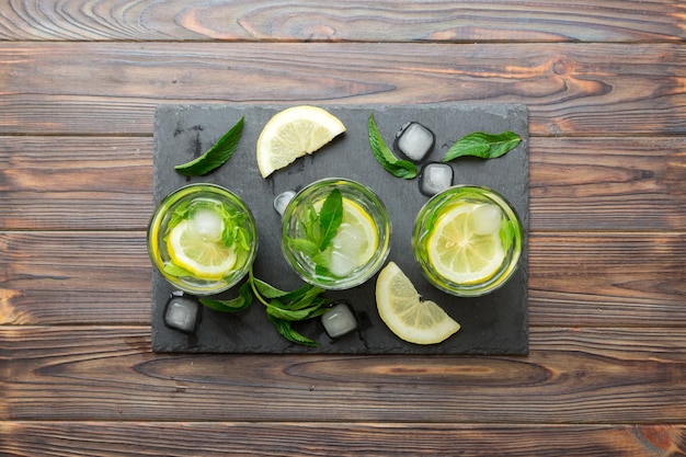 Caipirinha Mojito cocktail wodka of frisdrank drinken met limoen munt en stro op tafel achtergrond Verfrissende drank met munt en limoen in glazen bovenaanzicht plat lag