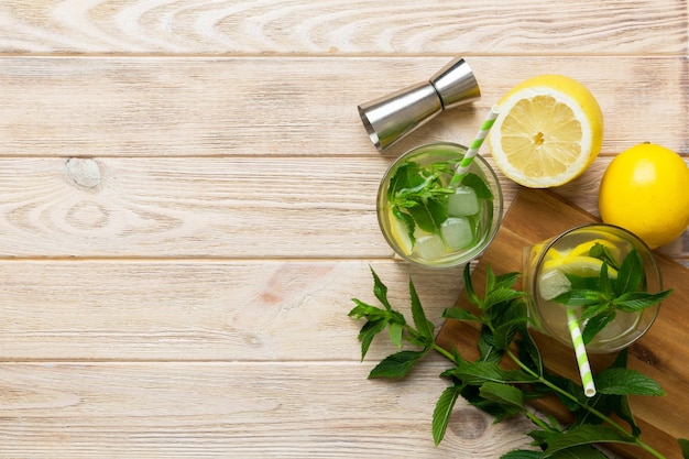 Caipirinha Mojito cocktail wodka of frisdrank drinken met limoen munt en stro op tafel achtergrond Verfrissende drank met munt en limoen in glazen bovenaanzicht plat lag