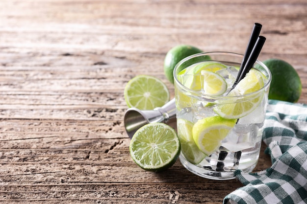 Caipiroska cocktail with lime on wooden table