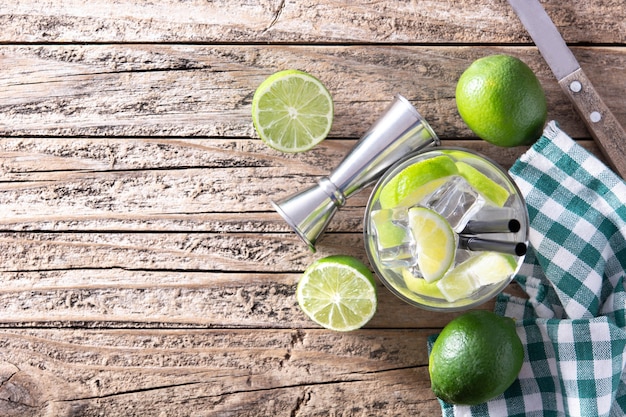 Caipiroska cocktail with lime on wooden table