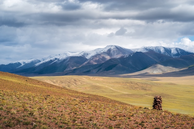 cairn on hillside on horizon is chikhachev ridge border between russia and mongolia autumn altai