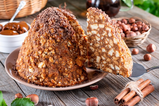 Cake anthill on a plate on the old wooden table. Traditional Russian cake