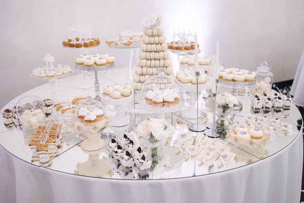 Cake bar on wedding differnt type of sweeties on the table eclair cake pops muffins and mamy others