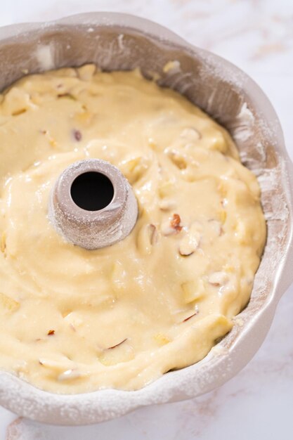 Cake batter in a bundt cake pan to bake apple bundt cake with caramel glaze