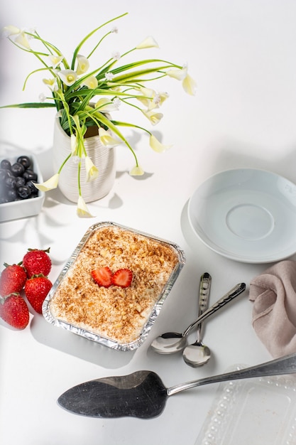 cake called tres leches with strawberries blueberries and cinnamon on white background