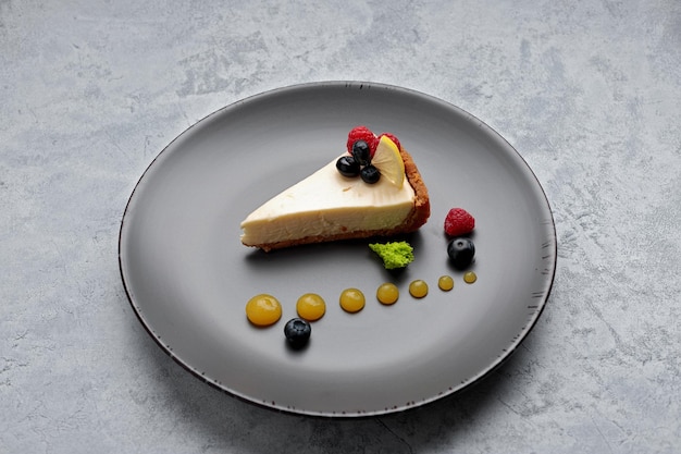 Cake Cheesecake with berries and lemon on a plate