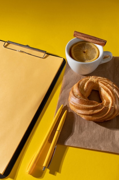 Cake, cup of tea and clipboard, top view.